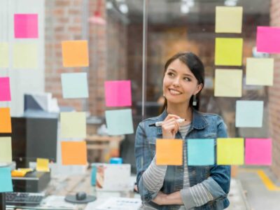 Latin American woman thinking of creative sales ideas at the office to put in a wall chart